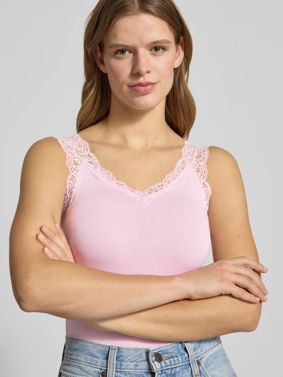 Frauenmodel trägt Slim Fit Tank Top aus Viskose-Mix Modell 'BARBERA LACE' von Pieces in Rosa mit Spitzenkante, Nahaufnahme Oberkörper. Unifarbene Jersey-Optik.