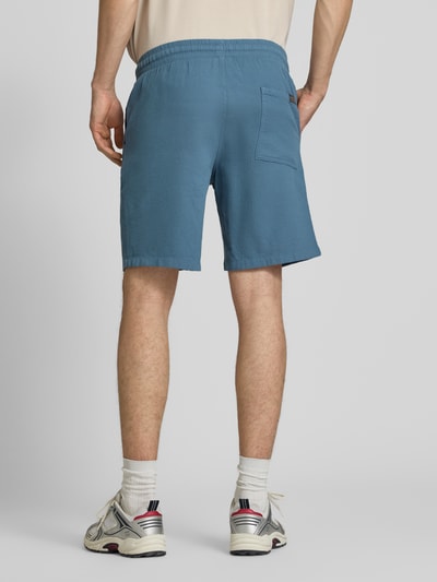 Männermodel draagt Shorts met structuurpatroon model 'JAIDEN' van Jack & Jones, puur katoen, regular fit, elastische band met tunnelkoord, bandwijdte maat M 43 cm, binnenbeenlengte maat M 23 cm, blauwe tint, rechte vormen, gladde textuur, ganzkörperansicht rückansicht.