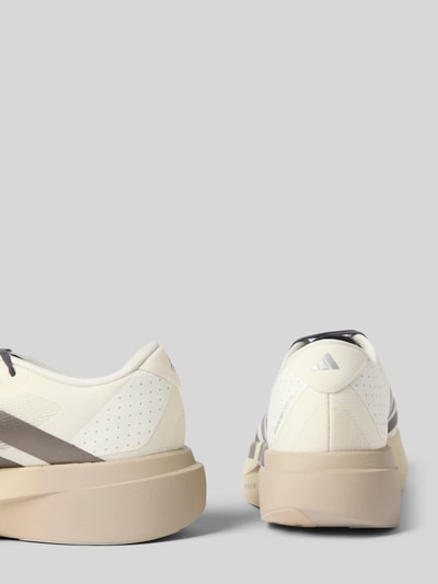 Produktfoto, Sneaker mit Schnürung von adidas Sportswear in Beige und Grau mit glatten und perforierten Flächen vor grauem Hintergrund.
