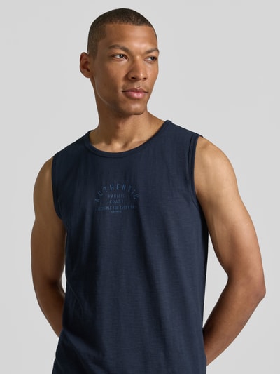 Männermodel trägt Tanktop mit Statement-Print und Rundhalsausschnitt von Lerros aus Reine Baumwolle im Regular-Fit, Rückenlänge 67 cm bei Größe M, dunkelblau, glatte Textur, dezentes Label-Patch, Nahaufnahme Oberkörper.