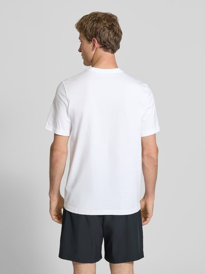 Männermodel trägt Herren T-Shirt mit Logo-Print Modell 'Swoosh' von Nike in Weiß aus Reine Baumwolle, Gerader-Schnitt, Rückenlänge 73 cm, Ganzkörperansicht Rückansicht.