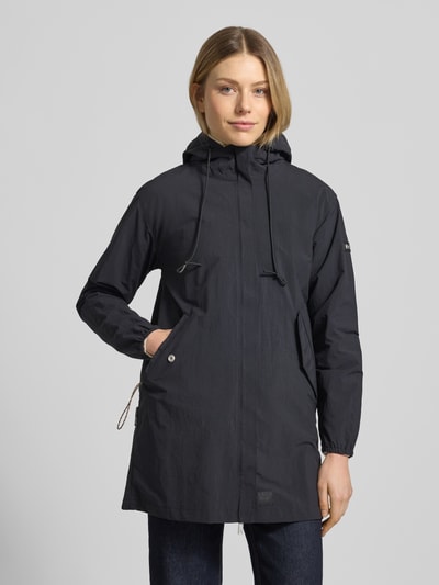 Modelka kobieca nosi Parka mit Label-Patches Modell 'AMETI' od khujo, czarny kolor, proste cięcie, kryty zamek, długość tyłu 81 cm, szerokość ramion 46 cm, szerokość klatki piersiowej 50 cm, długość rękawa 55 cm, widok całej sylwetki z przodu.