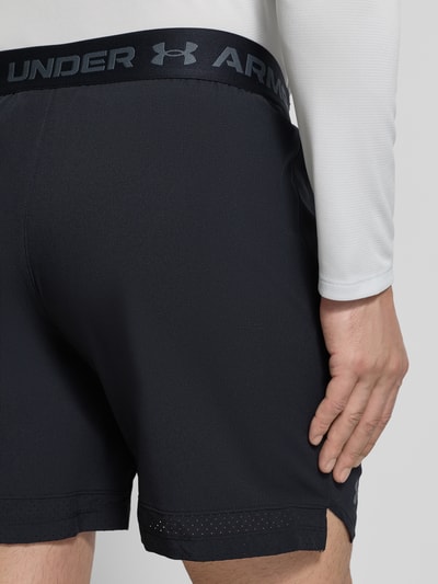 Männermodel trägt schwarze Straight Fit Shorts mit Logo-Print Modell 'Vanish' von Under Armour, elastischer Bund, Rückansicht Nahaufnahme