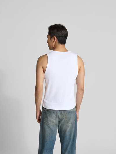 Männermodel trägt Top aus reiner Baumwolle von MAISON KITSUNÉ in Weiß mit Ripp-Optik, Label-Detail, eng anliegende Passform, Ärmelloses-Design, Rückenlänge 61 cm bei Größe M, Ganzkörperansicht Rückansicht.