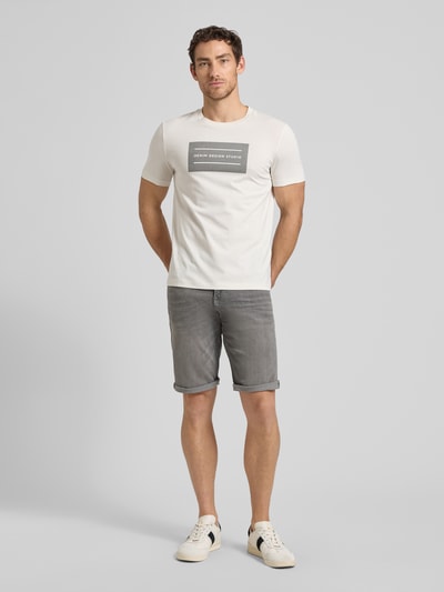 Männermodel trägt Regular Fit Jeans Bermudas aus Baumwoll-Mix von Tom Tailor in grauer Denim-Optik mit 5-Pocket-Design, Ganzkörperansicht von vorne.