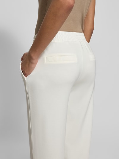 Kobiece modelka nosi Sweatpants mit elastischem Bund od Christian Berg Woman, białe, materiał z domieszką modalu, luźny krój, kieszenie boczne i z tyłu, detaliczna tekstura, zdjęcie z tyłu, zbliżenie na biodra.