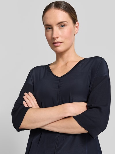 Frauenmodel trägt T-Shirt mit Ärmelaufschlag und Rundhalsausschnitt von Marc Cain, Baumwoll-Mix mit Stretch-Anteil, Label-Detail, Nahaufnahme Oberkörper