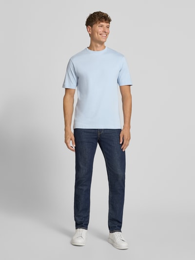 Männermodel trägt T-Shirt mit Rundhalsausschnitt von DRYKORN in Hellblau, Slim-Fit, Reine Baumwolle, Rückenlänge 69 cm bei Größe M, Ganzkörperansicht von vorne.