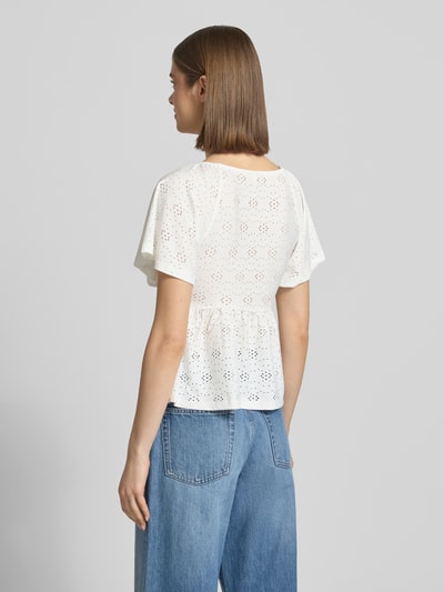 Modelka prezentuje Slim Fit T-Shirt mit tiefem V-Ausschnitt Modell 'SMILLA' od Only, biały, kwiatowy wzór, krótki rękaw, stretch, efekt lekko przezroczysty, krój slim fit, zdjęcie całej sylwetki z tyłu.