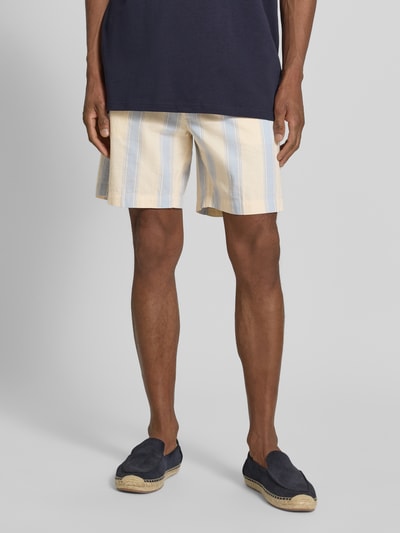 Männermodel trägt Regular Fit Shorts aus reiner Baumwolle von Armedangels, Optik:Allover-Muster, gestreift, Nahaufnahme Unterkörper.