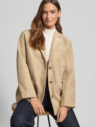 Kobiece modelka nosi Regular Fit Blazer in Leder-Optik Model 'APALA' von B.Young, beżowa imitacja skóry z kołnierzem z połami, kieszenie z patką, zapięcie na guzik, dł. tyłu w rozmiarze 36: 72 cm, szerokość ramion w rozmiarze 36: 46 cm, szerokość klatki piersiowej w rozmiarze 36: 54 cm, długość rękawów w rozmiarze 36: 59 cm, tekstura matowa, przód w całej okazałości, zbliżenie na górę ciała.