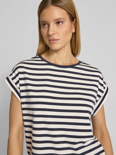 Modelka kobieca ma na sobie Oversized T-Shirt mit Label-Detail od Smith and Soul z bawełnianej mieszanki z lyocellem, wzór w granatowo-białe paski, dekolt okrągły, długość tyłu w rozmiarze S: 60 cm, zbliżenie na górną część ciała z przodu.