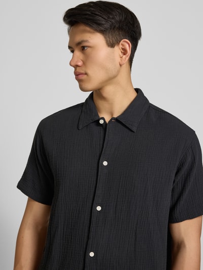 Männermodel trägt Regular Fit Freizeithemd mit Kentkragen von Jack & JonesR in Schwarz, reine Baumwolle, Nahaufnahme Oberkörper.