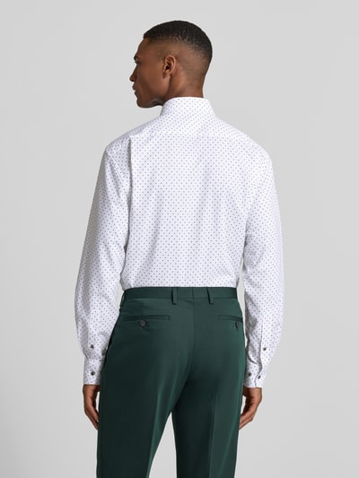 Männermodel trägt Regular Fit Businesshemd aus reiner Baumwolle mit Kentkragen von OLYMP, weiß mit feinem Muster, Rückenansicht, Ganzkörperansicht. Langärmeliges Design mit Sportmanschetten, durchgehender Knopfleiste und Brusttasche, kombiniert mit grüner Hose.