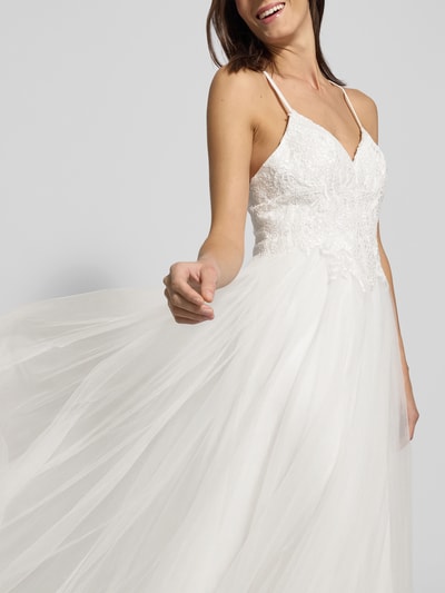 Modelka kobieca nosi Brautkleid mit floralen Stickereien od Mascara, białe, koronki, spaghettiträger, sercowy dekolt, rozkloszowany dół, widoczne hafty, materiał kryjący, przezroczysta warstwa wierzchnia, widoczna stola, zapięcie na tylnej części, całkowita długość sukni 122 cm, szerokość w biuście 36 cm, zbliżenie na górną część, widok z przodu.