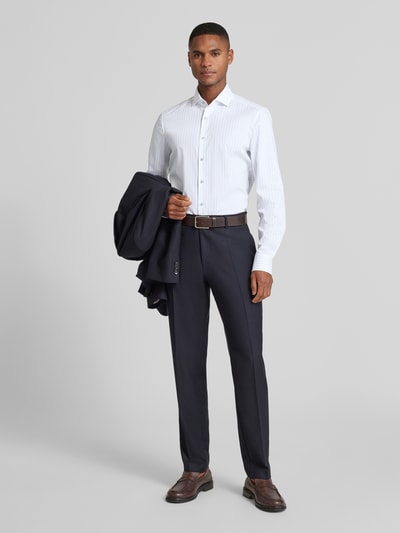 Männermodel trägt Slim Fit Businesshemd aus Baumwoll-Mix mit Kentkragen von OLYMP Level Five in Weiß mit feinem Streifenmuster, vorne Ganzkörperansicht. Elastischer Stoff, durchgehende Knopfleiste, Langarm, Sportmanschetten, kombinierbar mit Business-Hose.