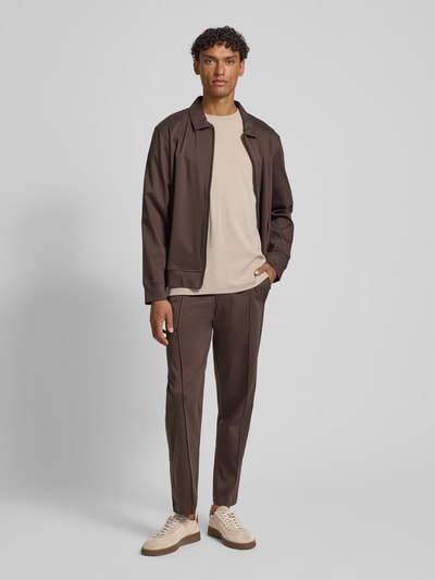 Männermodel trägt braune Sweatpants mit Eingrifftaschen Modell 'Josemiguel' von JOOP! Collection, Straight Fit, Ganzkörperansicht von vorne.