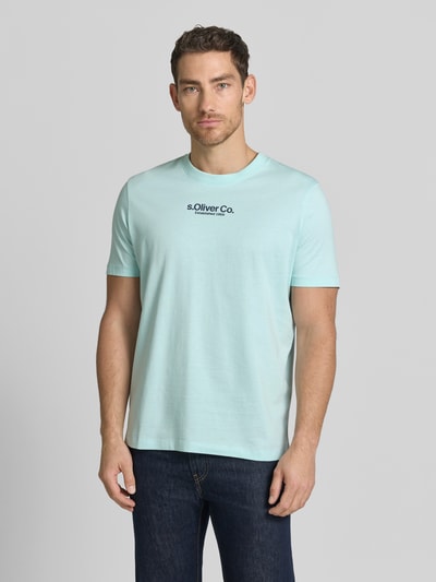 Männermodel trägt Regular Fit T-Shirt aus reine katoen van s.Oliver RED LABEL, lichtblauw, unikleur, labelprint, ronde hals, korte mouw, ganzkörperansicht von vorne.