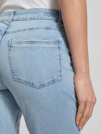 Frauenmodel trägt Flared Jeans mit Knopfverschluss von Christian Berg Woman, hellblauer Baumwoll-Mix, 5-Pocket-Design, Nahaufnahme Rückansicht