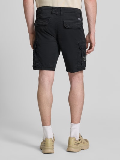 Männermodel trägt Regular Fit Bermudas mit Cargotaschen von Petrol, Baumwoll-Mix mit Stretch-Anteil, Schwarz, Ganzkörperansicht Rückansicht.