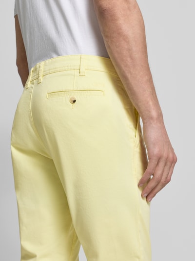 Männermodel trägt Straight Fit Chino mit Eingrifftaschen von MCNEAL, gelber Baumwoll-Mix, Detailaufnahme Rückansicht, Kontext Herrenmode.