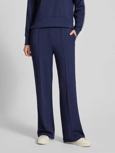 Kobiece model nosi Sweatpants mit elastischem Bund od Christian Berg Woman, granatowy kolor, materiał z domieszką modalu, luźny krój, francuskie kieszenie, widok całej sylwetki z przodu.