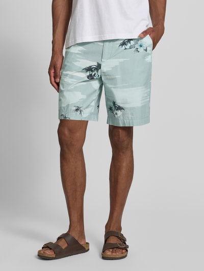 Männermodel trägt Straight Leg Chinoshorts aus reiner Baumwolle von BOSS Orange, Optik:Allover-Muster, Hawaii-Muster, Passform: Regular-Fit, Gürtelschlaufen, Knopf und Reißverschluss, Material: reine Baumwolle, Pastelltöne, Nahaufnahme Oberschenkel bis Knie, Ganzkörperansicht von vorne.