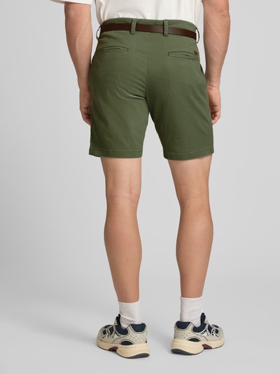 Männermodel trägt Straight Fit Shorts mit abnehmbarem Gürtel Modell 'Adam' von Jack & Jones in Olivgrün aus Baumwoll-Mix, Ganzkörperansicht Rückansicht. Herren Shorts mit Eingriffstaschen und Gesäßtaschen, Knopf- und Reißverschluss, Bundweite 40 cm, Innenbeinlänge 19 cm.