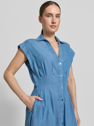 Frauenmodel trägt blaues Kurzarm-Kleid mit Knopfleiste und Umlegekragen, glatte Textur, Nahaufnahme Oberkörper.