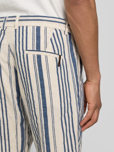 Männermodel trägt Bermudas aus lyocellmix model 'JUNO' van CINQUE met all-over look in blauw en beige met steekzakken, detailaufnahme rechterheup