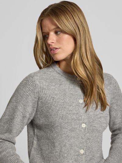 Frauenmodel trägt graue Damen Strickjacke mit Woll-Anteil Modell 'SILLY' von PIECES, feine Rippstruktur, Nahaufnahme Oberkörper.