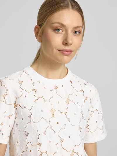 Frauenmodel trägt Regular Fit T-Shirt aus Spitze Modell 'SALLIE' von Vero Moda in Weiß mit Blumenmuster, Baumwoll-Mix, Nahaufnahme Oberkörper.