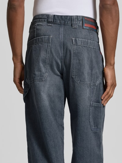 Männermodel trägt Wide Fit Jeans mit Eingrifftaschen von Diesel, blaue Baumwolle, sichtbare Gesäßtaschen, Ganzkörperansicht Rückansicht.