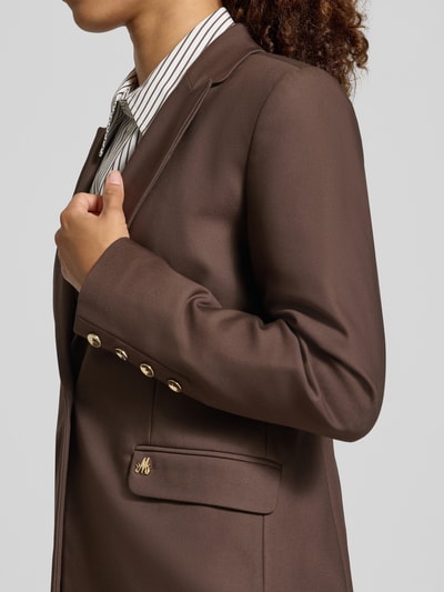Frauenmodel trägt Blazer aus Baumwoll-Mix Modell 'Blake' von MOS MOSH in Dunkelbraun mit Klappentaschen, Reverskragen, Detailaufnahme, taillierte Passform, glatte Textur, Nahaufnahme Oberkörper.