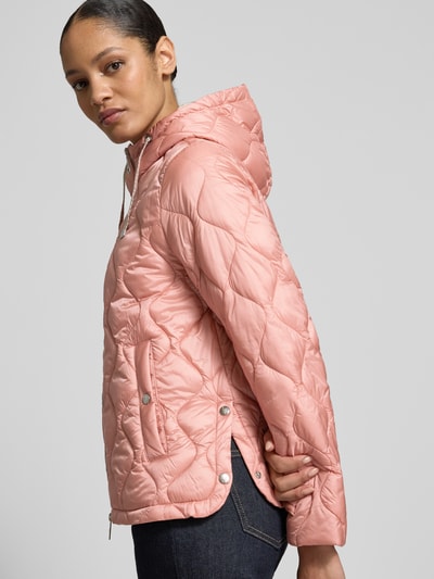 Vrouwenmodel draagt Gewatteerd jack met capuchon en tweewegritssluiting van Fuchs Schmitt in regular fit, steekzakken, ruglengte 62 cm, schouderbreedte 42 cm, borstwijdte 53 cm, mouwlengte 61 cm, roze kleur, zachte glanzende textuur, zijaanzicht, bovenzijde.