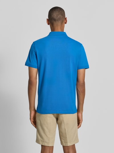 Männermodel trägt Regular Fit Poloshirt aus reiner Baumwolle von Tom Tailor, kräftiges Blau, glatte Textur, Ganzkörperansicht Rückansicht.