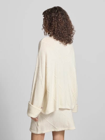 Frauenmodel trägt Regular Fit Pullover mit Alpaka-Anteil Modell 'Liora' von OH APRIL, cremefarbener Strick, extralange Ärmel, Rückansicht, Ganzkörperansicht.