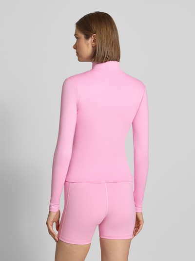 Frauenmodel trägt Nike Slim Fit Trainingsjacke mit Dri-FIT ADV Technology, einfarbig rosa, glatte Textur, Damen Trainingsjacke, Ganzkörperansicht Rückansicht