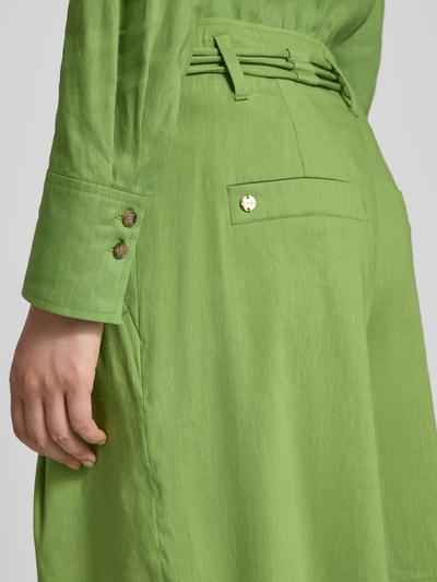 Vrouwenmodel draagt Wide Fit Shorts uit linnenmix met viscose van Marc Cain, steekzakken, bandplooien, haakjes- en ritssluiting, detailopname heup