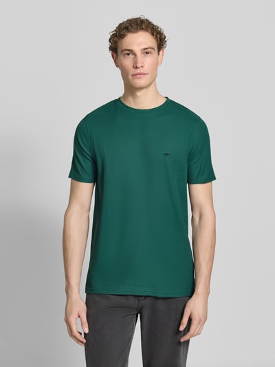 Männermodel trägt Regular Fit T-Shirt mit Logo-Stitching von Fynch-Hatton in Grün, Reine Baumwolle, Rundhalsausschnitt, Rückenlänge 68 cm, Ganzkörperansicht von vorne.