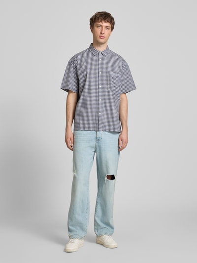 Männermodel trägt Loose Fit Jeans aus reiner Baumwolle Modell 'FADE' von Only & Sons mit Destroyed-Details in Denim-Optik, Ganzkörperansicht von vorne.