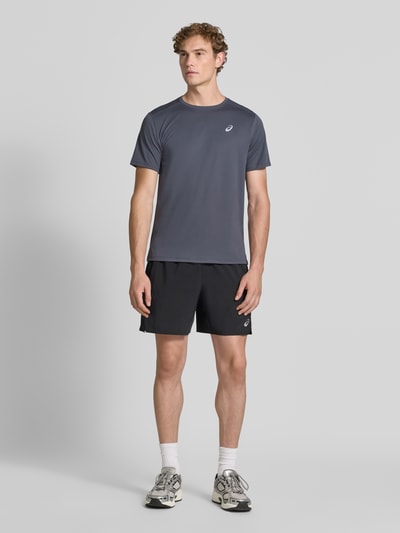 Męski model nosi t-shirt z logo-Print Model 'CORE' od ASICS TIGER, prosty krój, okrągły dekolt, Długość tyłu w rozmiarze M: 72 cm, Ganzkörperansicht von vorne.