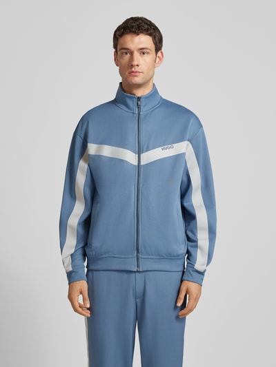 Männermodel trägt Relaxed Fit Sweatjacke mit Chevron-Tape Modell 'DARTI' von HUGO, Optik: Unifarben, Sweat, Ganzkörperansicht von vorne.