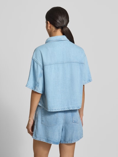 Vrouwenmodel draagt Regular Fit overhemdblouse uit puur lyocell model 'Saphina' van MSCH Copenhagen, denimlook, halflange mouwen, overhemdkraag, doorlopende knoopsluiting, ruglengte maat S/M 53 cm, mouwlengte 22 cm, lichtblauw, rechte vormen, effen textuur. Ganzkörperansicht Rückansicht.