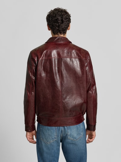 Männermodel trägt Regular Fit Jacke in Leder-Optik mit Umlegekragen von Emporio Armani, dunkelrot, glatte Struktur, Ganzkörperansicht Rückansicht.