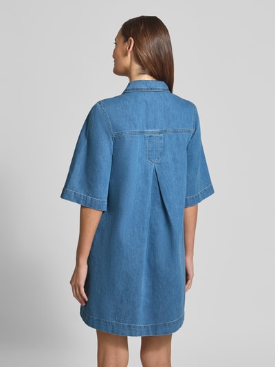 Frauenmodel trägt Jeanskleid mit Brusttaschen Modell 'Mira' von mbyM, reine Baumwolle, Relaxed-Fit Minikleid, Rückenlänge 89 cm, Ganzkörperansicht Rückansicht.