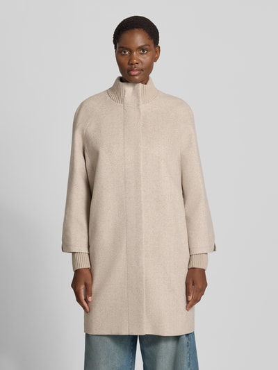Frauenmodel trägt Mantel aus Woll-Mix mit gestricktem Stehkragen von COMMA in Beige, sichtbarer Druckknopfverschluss, Straight Fit, seitliche Eingrifftaschen, Nahaufnahme Oberkörper.