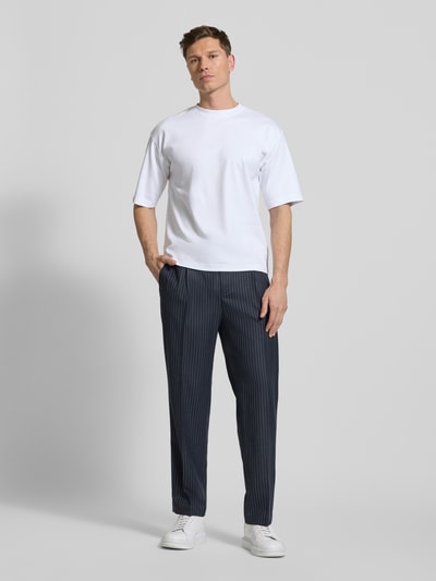 Männermodel trägt Relaxed Fit T-Shirt aus reiner Baumwolle von JAKE*S STUDIO MEN in Weiß, Halbarm, kombiniert mit dunkler gestreifter Hose, Ganzkörperansicht von vorne.