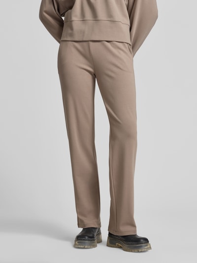 Vrouwenmodel draagt Flared Fit Sweatpants met Tunnelkoord van Juvia in beige, mix van katoen en modal, steekzakken, elastische band, geheel van voren.