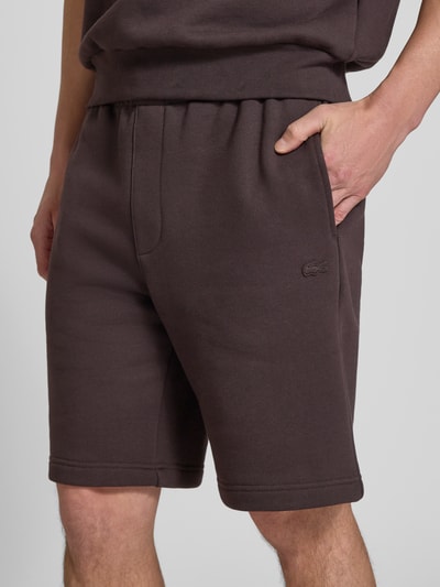 Männermodel trägt Relaxed Fit Sweatshorts aus reiner Baumwolle von Lacoste, Optik: Unifarben, Logo-Detail, Tunnelzug, Bundabschluss: Elastisch, seitliche Eingrifftaschen, Gesäßtaschen, Materialverarbeitung: Sweat, Nahaufnahme Oberschenkel